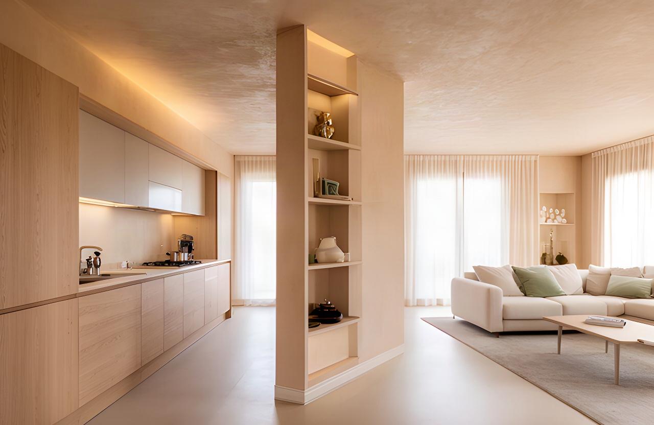 Zona giorno di una villa bifamiliare a Vignola con cucina color sabbia, rovere naturale e luce diffusa